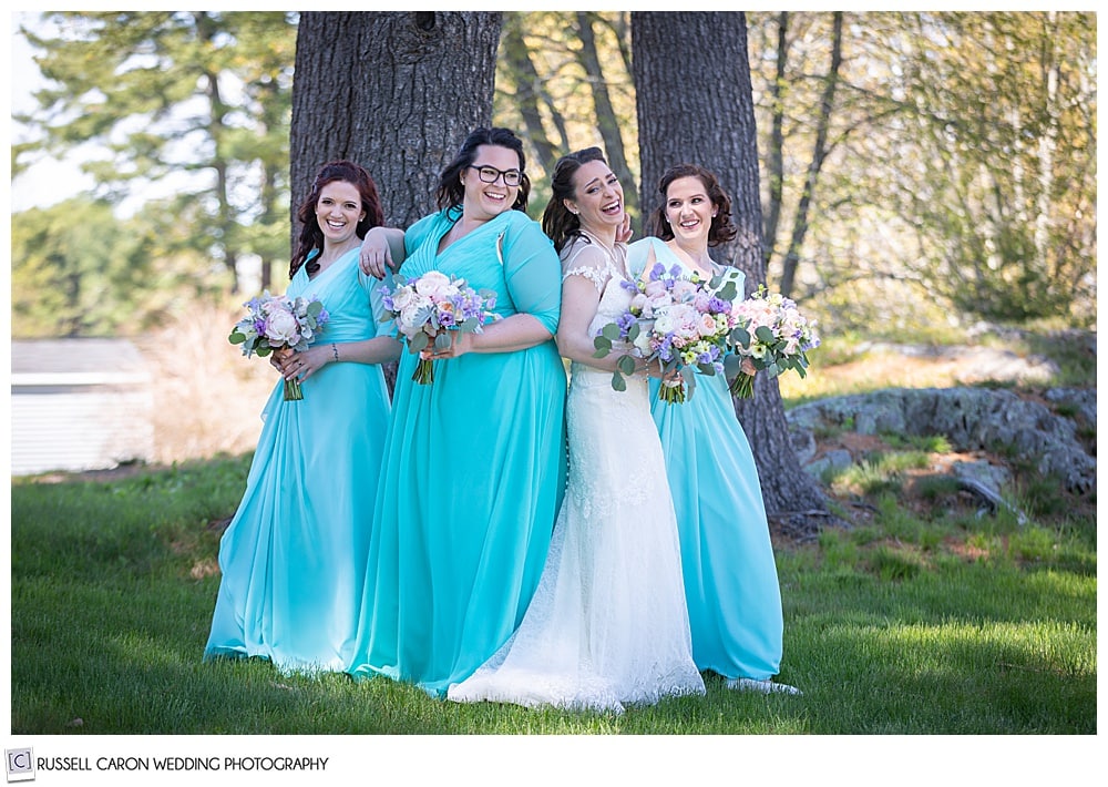 bride and bridesmaids standing close together and laughing