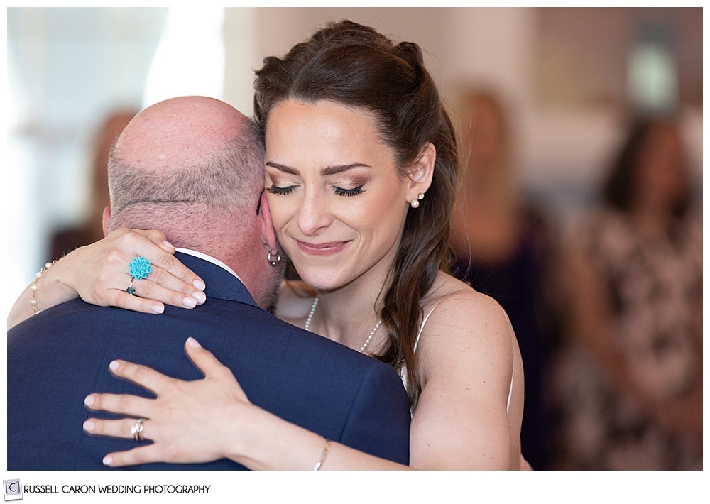 bride smiling while she dances with her step father