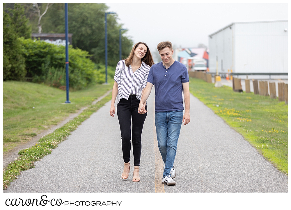 man and woman walking toward the camera, holding hands, in Portland, Maine. Southern Maine weddings