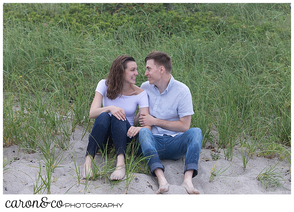 man and woman sitting near the dunes at Biddeford Pool Beach