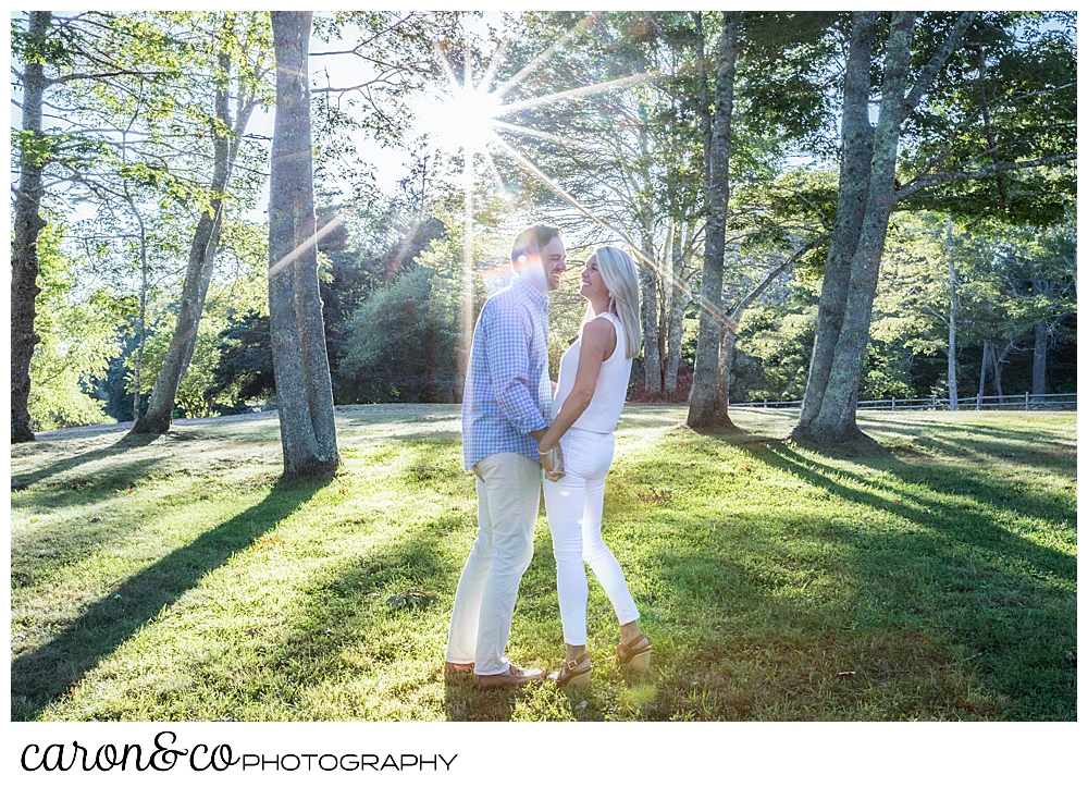 man and woman standing together in a park, with a sun flare overhead