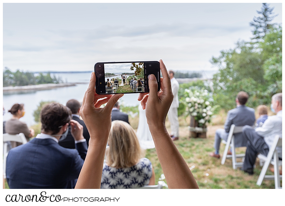 a guest takes a phone photo at a Grey Havens Inn wedding, Georgetown Maine