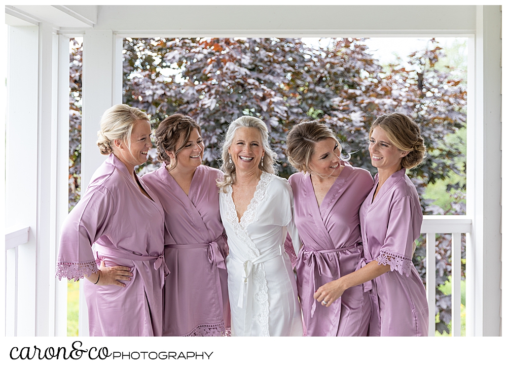 bride and bridesmaids in bathrobes, laughing during a Scarborough Maine wedding