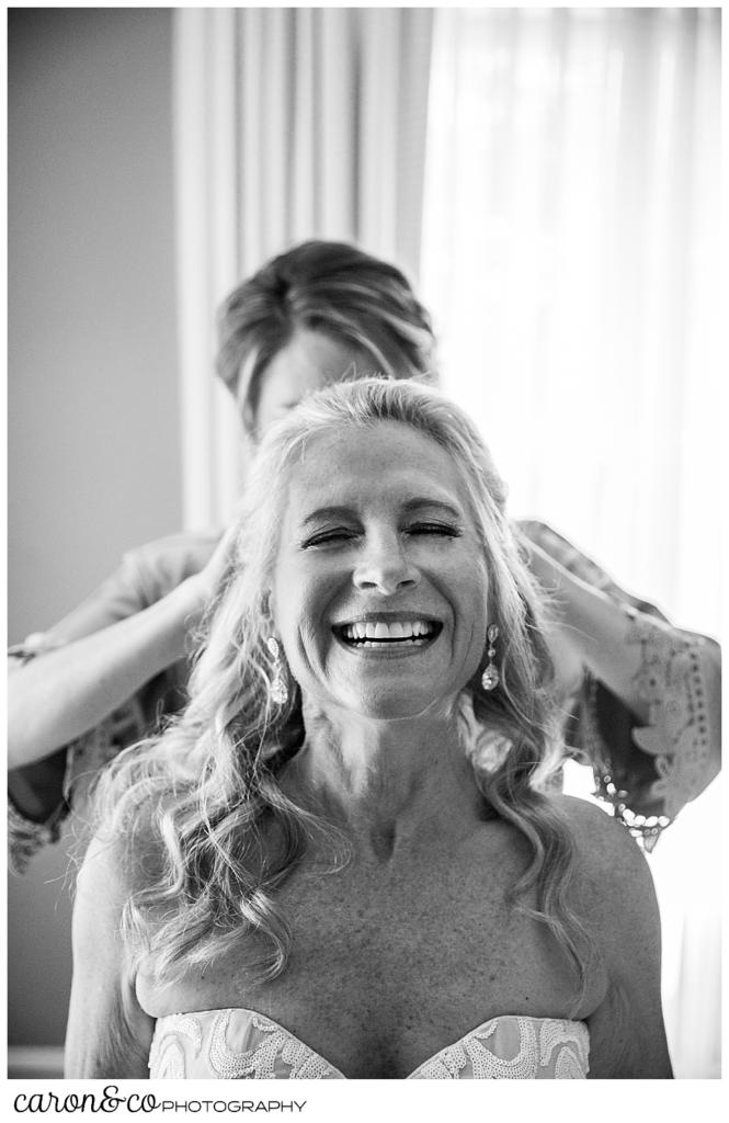 black and white photo of a bridesmaid helping a bride with her veil during a scarborough maine wedding