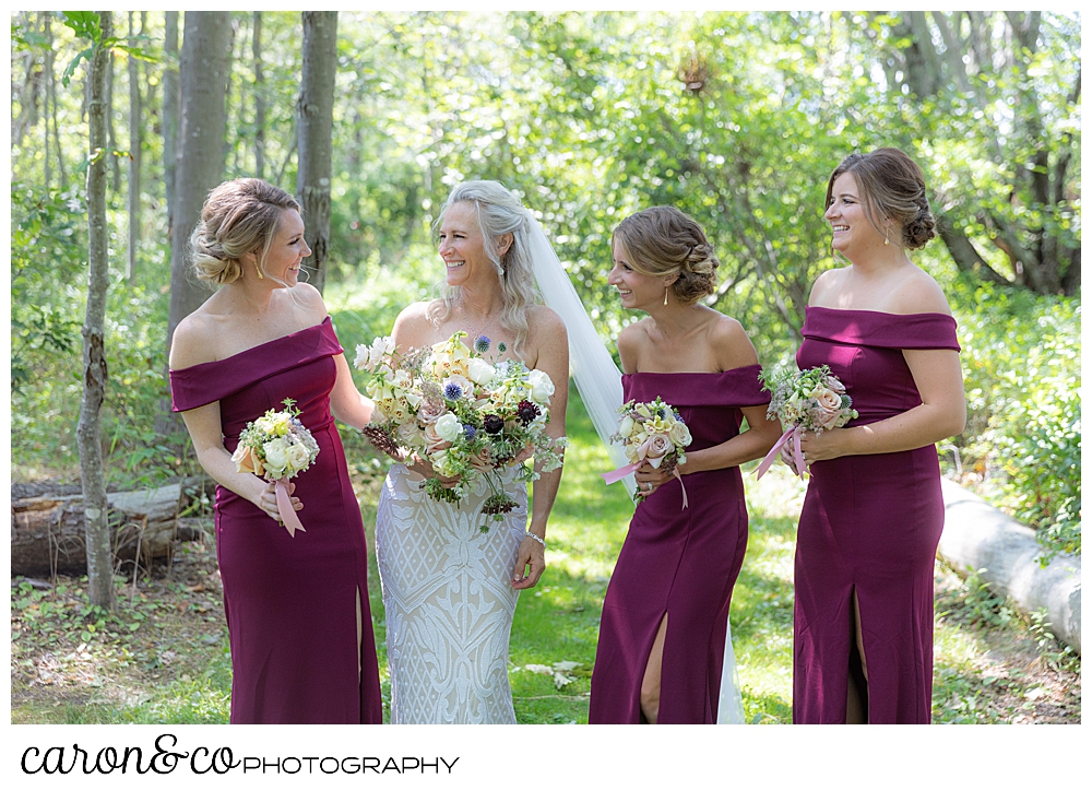 bride, and bridesmaids in dark red dresses, laugh together