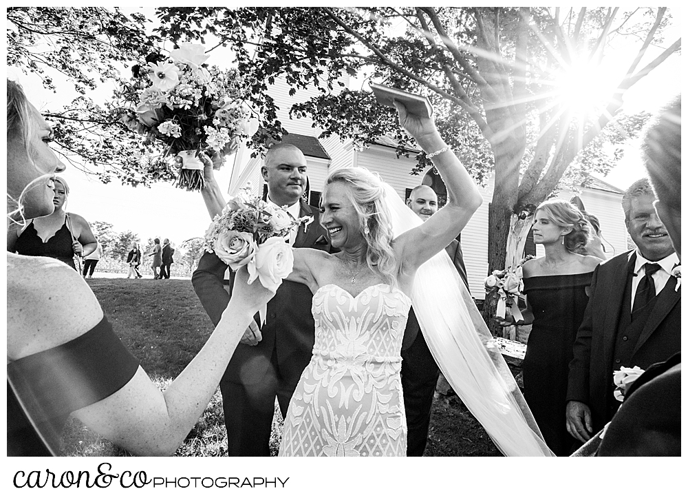 black and white photo of bride with raised arms, smiling