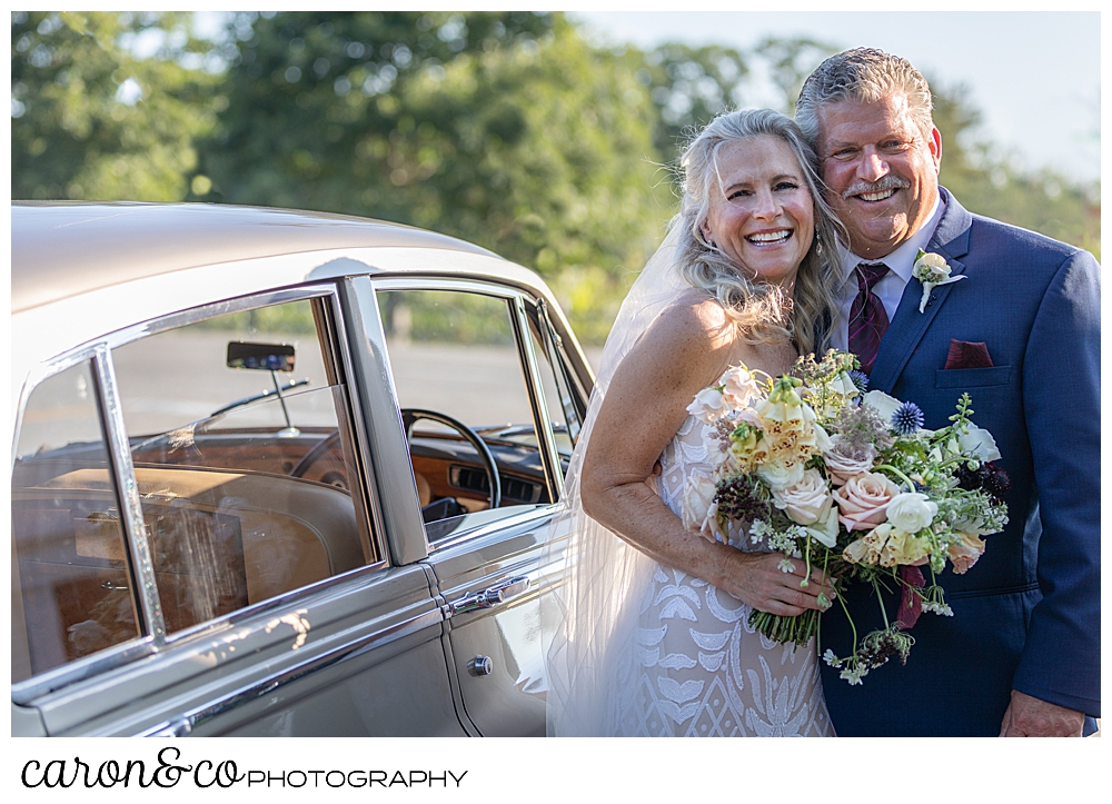 bride and groom standing next to their getaway car, a Bentley from Maine Limousine Service