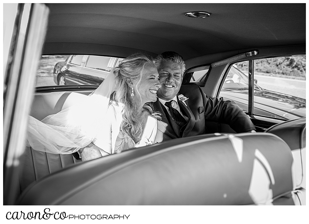 black and white photo of a bride and groom in their getaway car