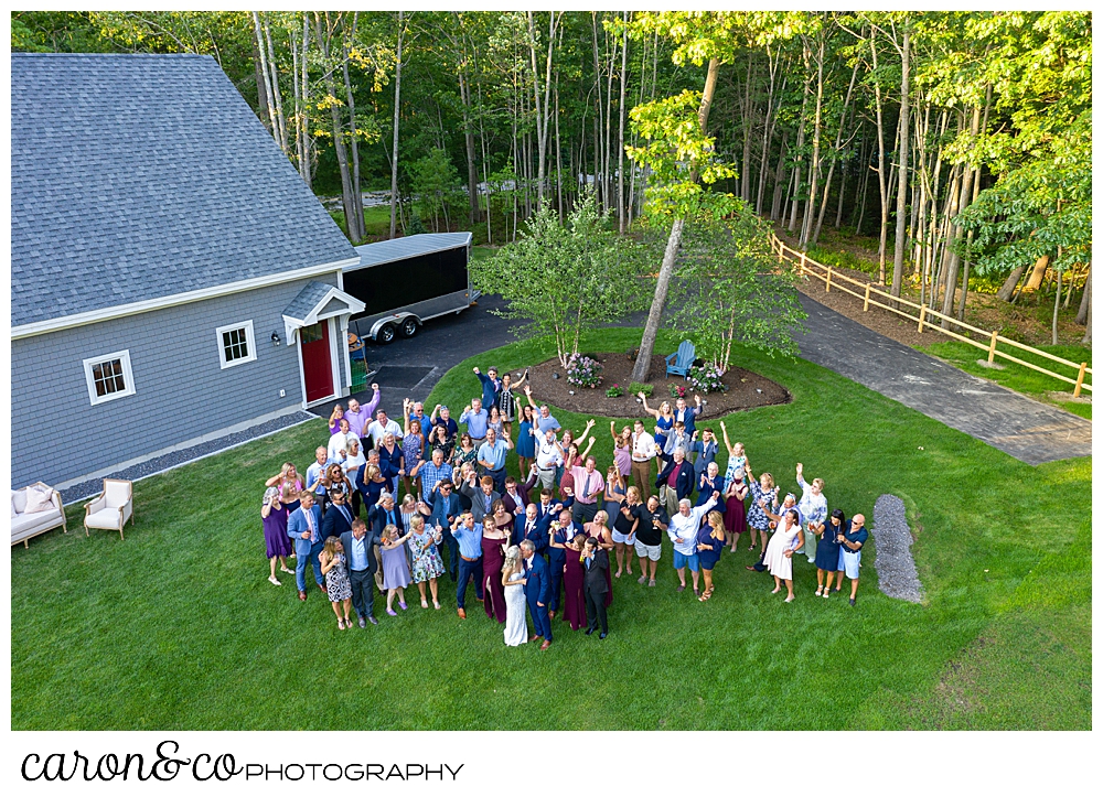 drone photo of a bride and groom, in their back yard, surrounded by their guests 