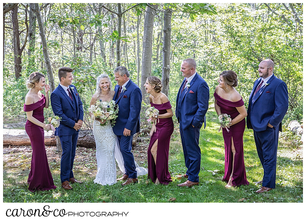 bride and groom with their bridal party in the woods, having fun