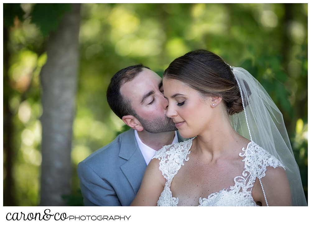 sweet summertime wedding in new england, groom is kissing the bride on her cheek