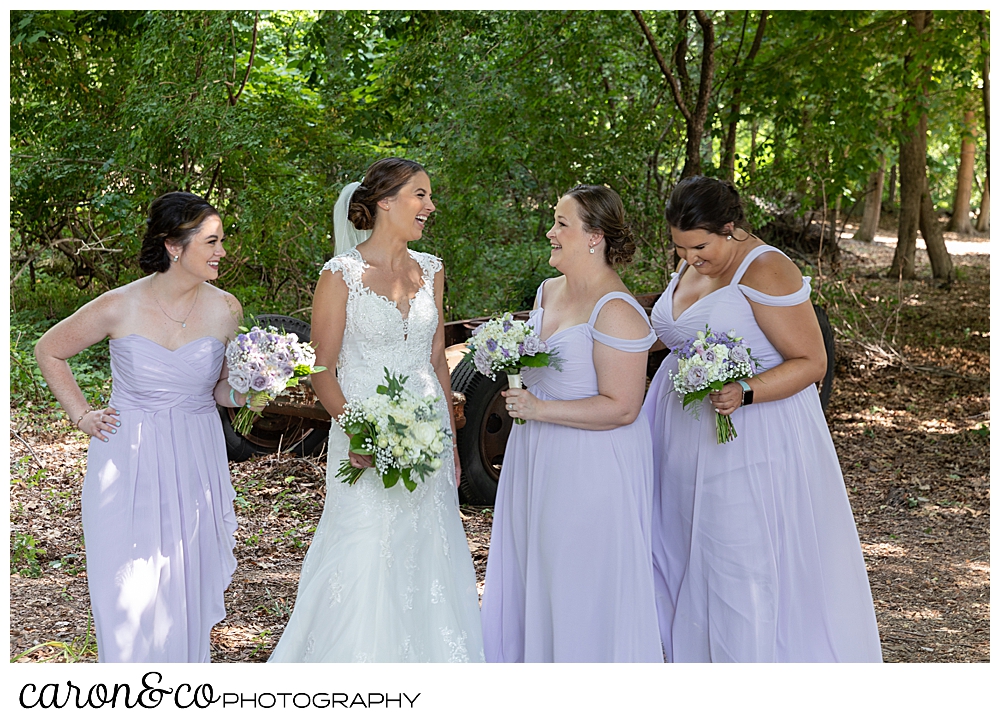 sweet summertime wedding photo of bride and bridesmaids laughing together 