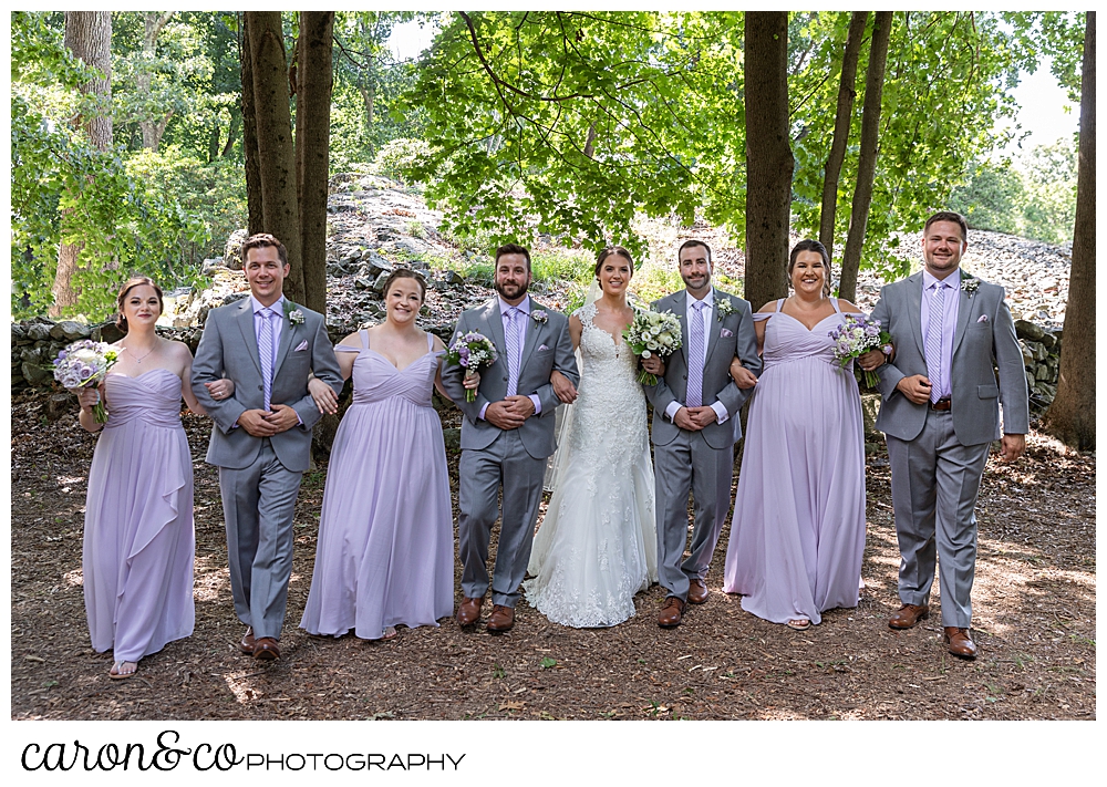 sweet summertime wedding photo of a bridal party linking arms 