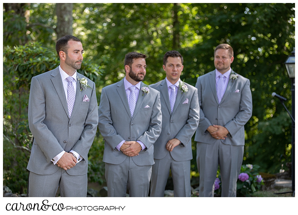 sweet summertime wedding photo of groom and groomsmen at the wedding ceremony site