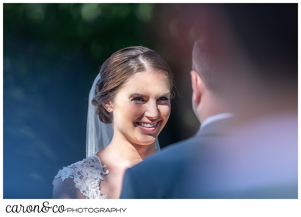 sweet summertime wedding ceremony photo of the bride smiling at the groom