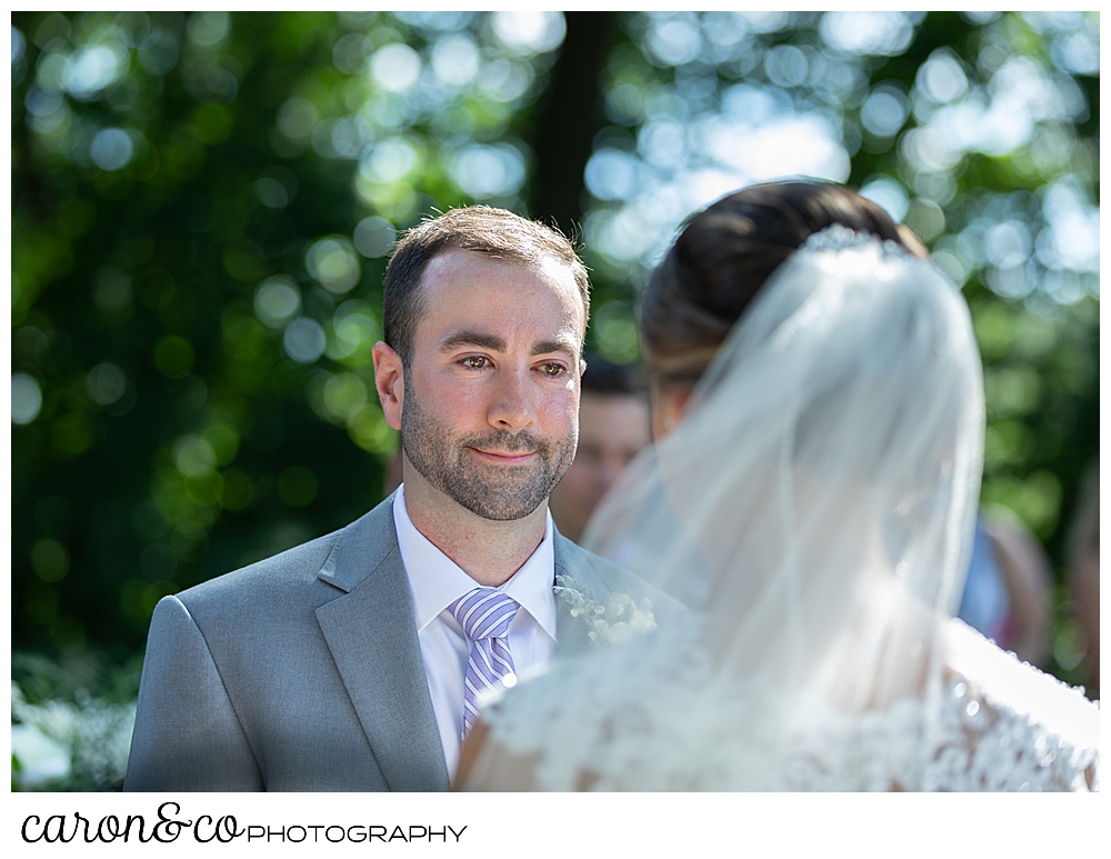 sweet summertime wedding ceremony photo of the groom looking at the bride