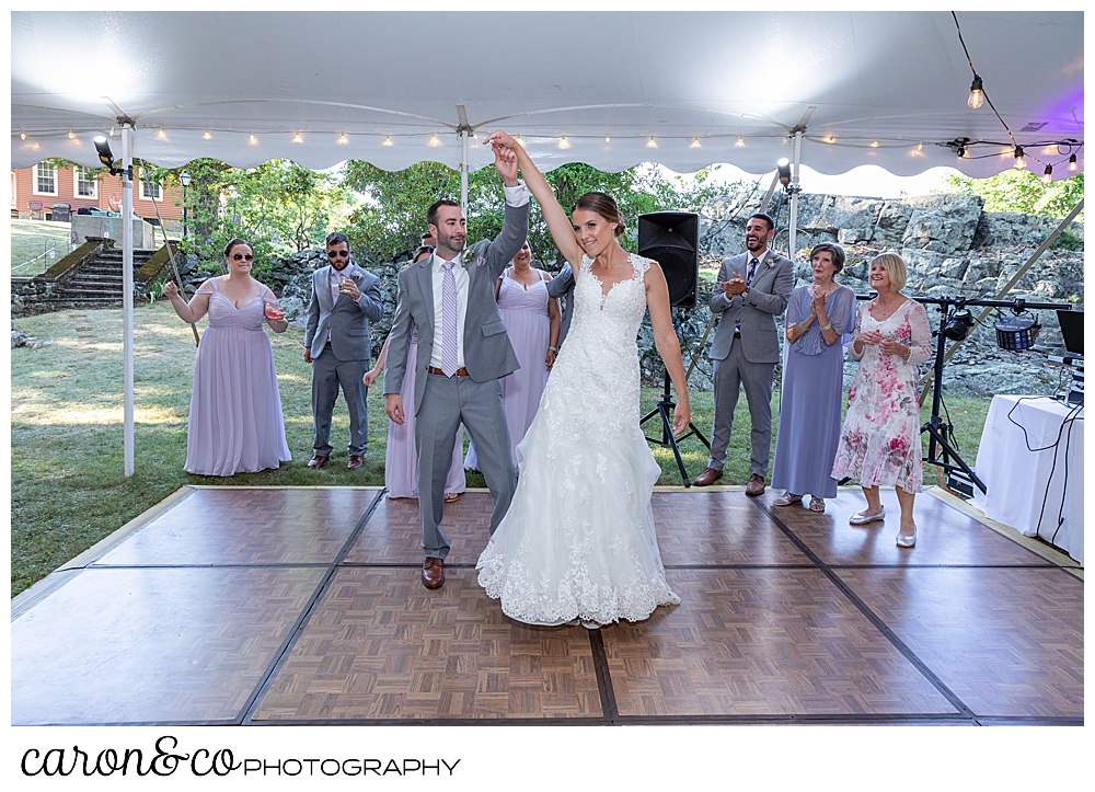 sweet summertime wedding reception photo of the bride and groom on the dance floor, their wedding party standing behind them