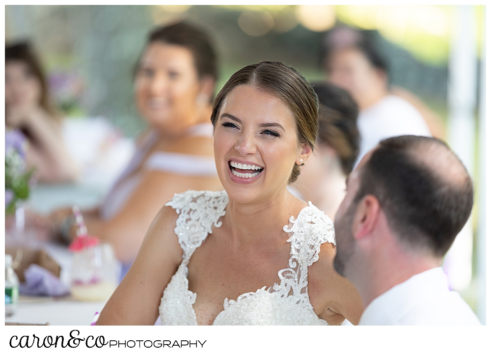 sweet summertime wedding reception photo of the bride laughing during the toasts