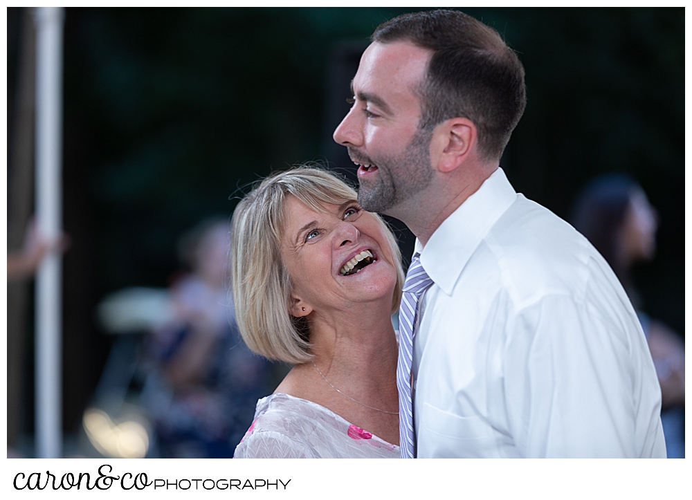 sweet summertime wedding reception photo of groom and his mother dancing and laughing