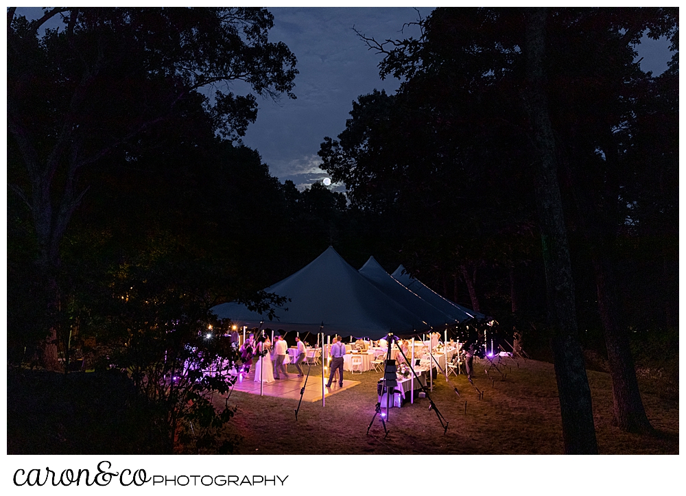 sweet summertime wedding reception photo of a tented reception after dark