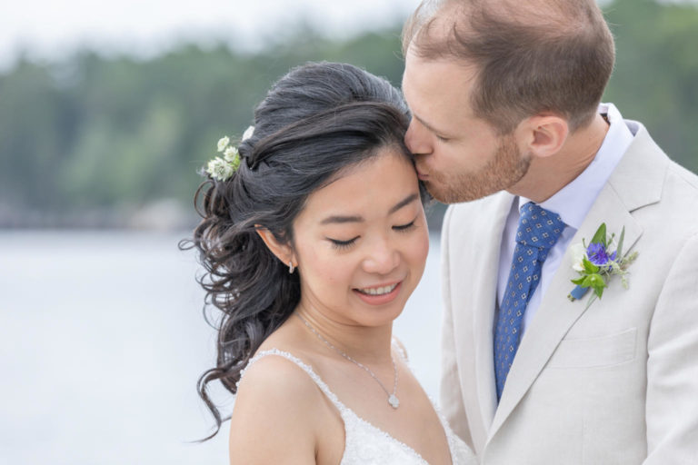 groom kissing bride's forehead duringGrey Havens Inn, Georgetown Maine wedding