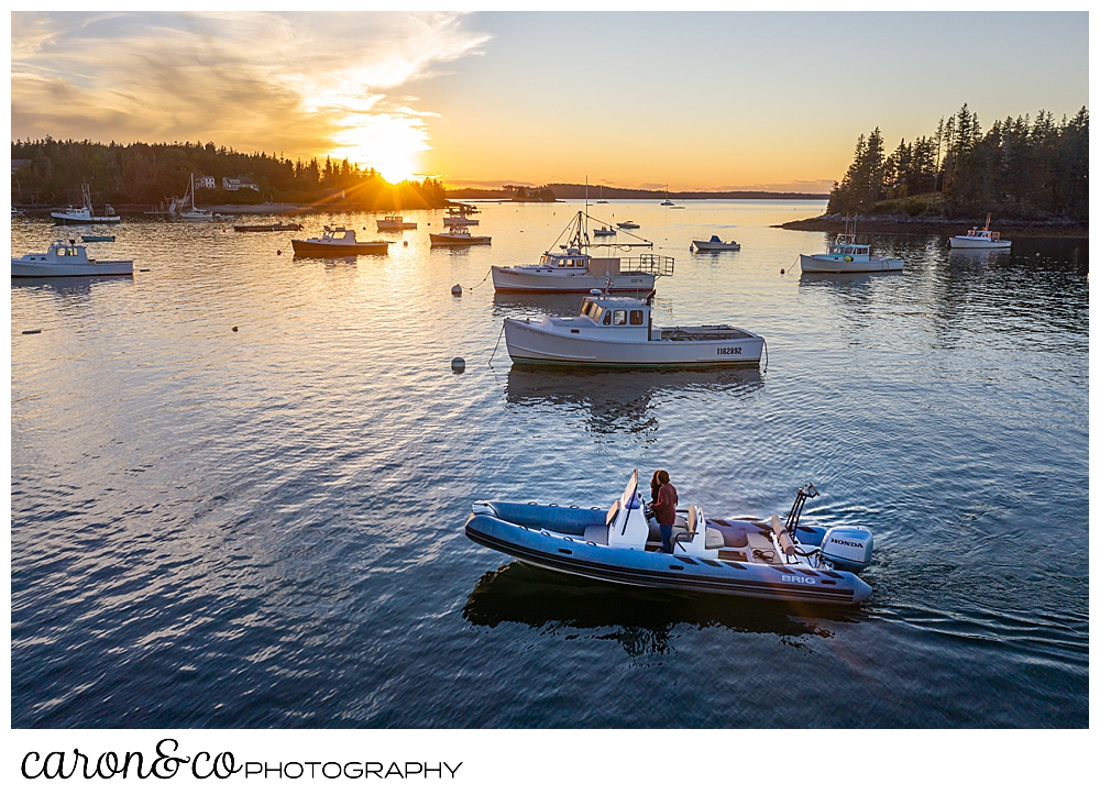 a man and a woman are driving a Brig inflatable boat during sunset, at their Port Clyde Maine engagment