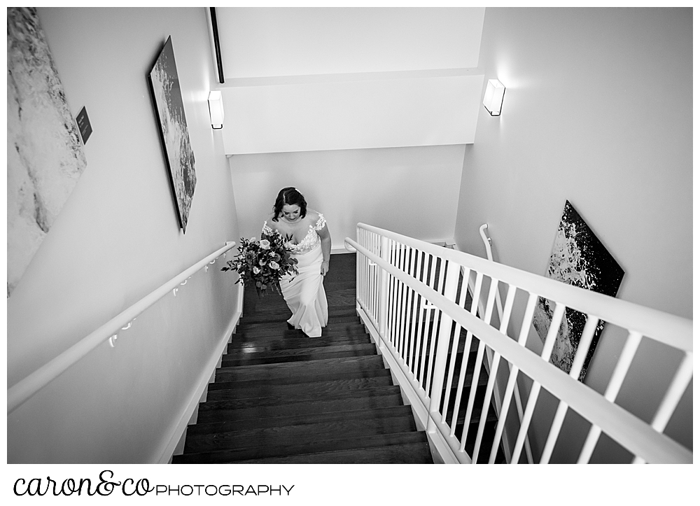 a black and white photo of a bride walking up the stairs to her ceremony at a Portland Press Hotel wedding 