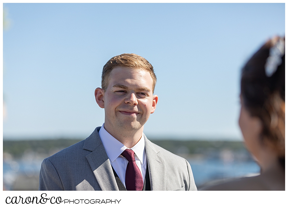 a groom smiles as his bride approaches