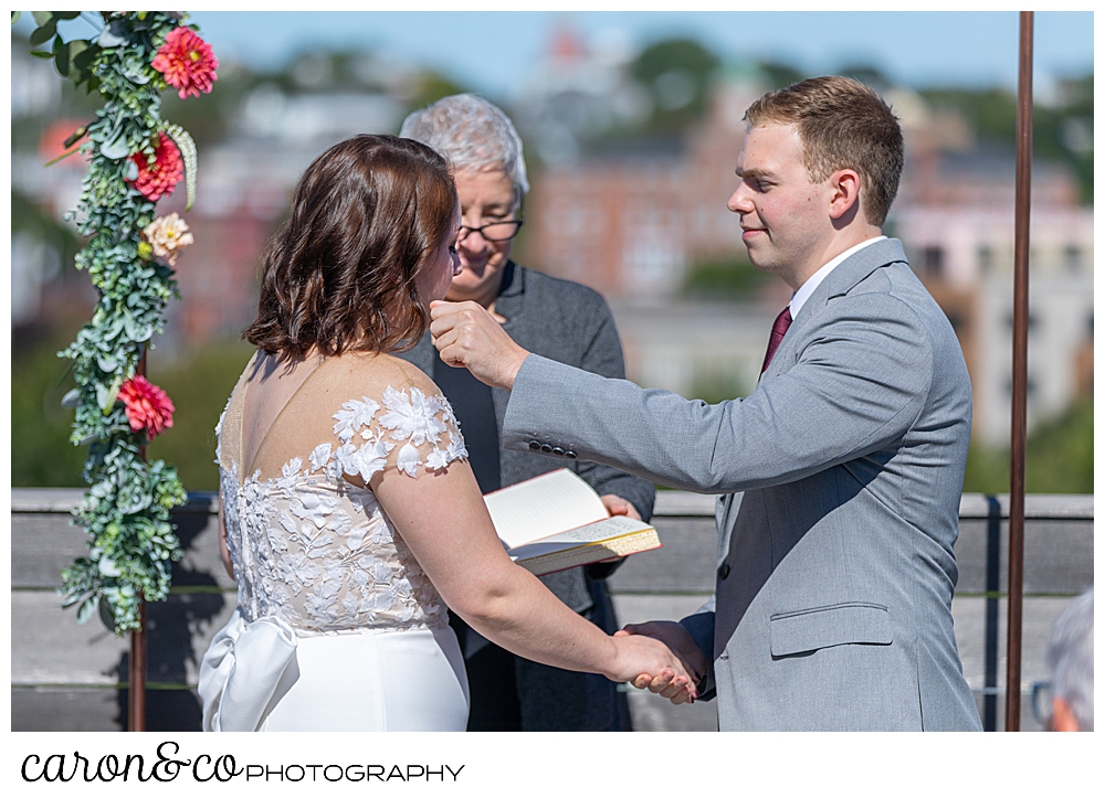 a groom reaches out to wipe a tear from his bride's cheek