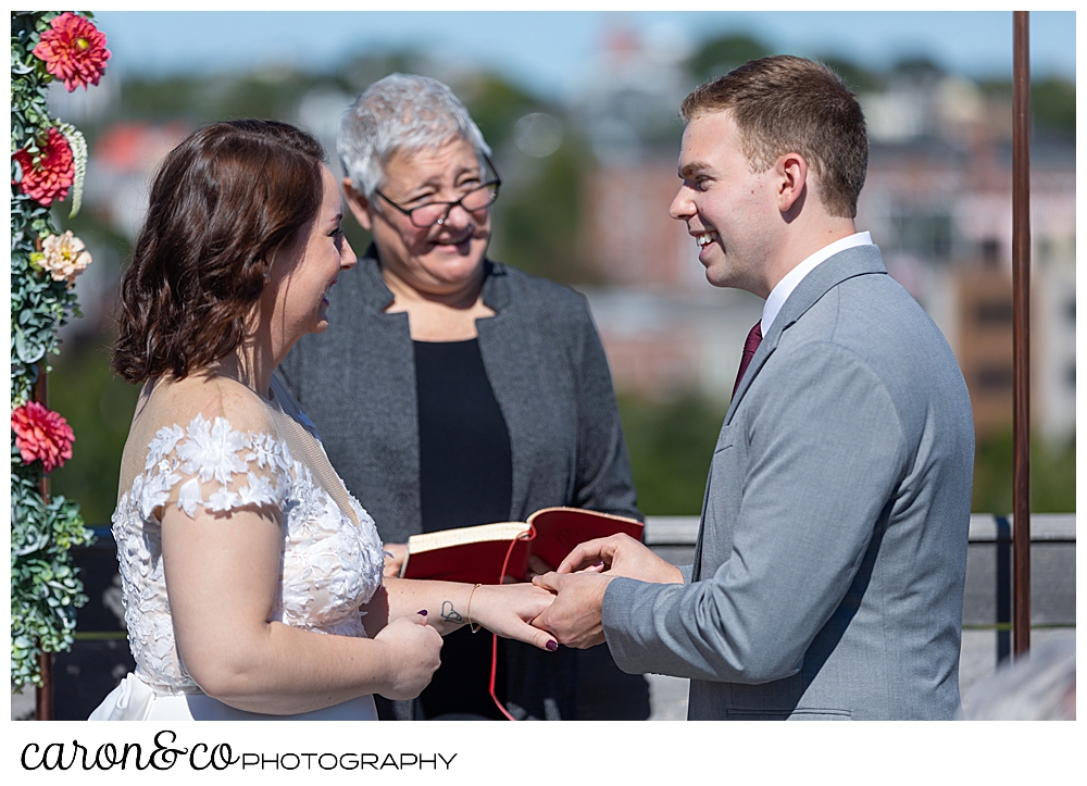 a groom puts a wedding band on his bride's finger