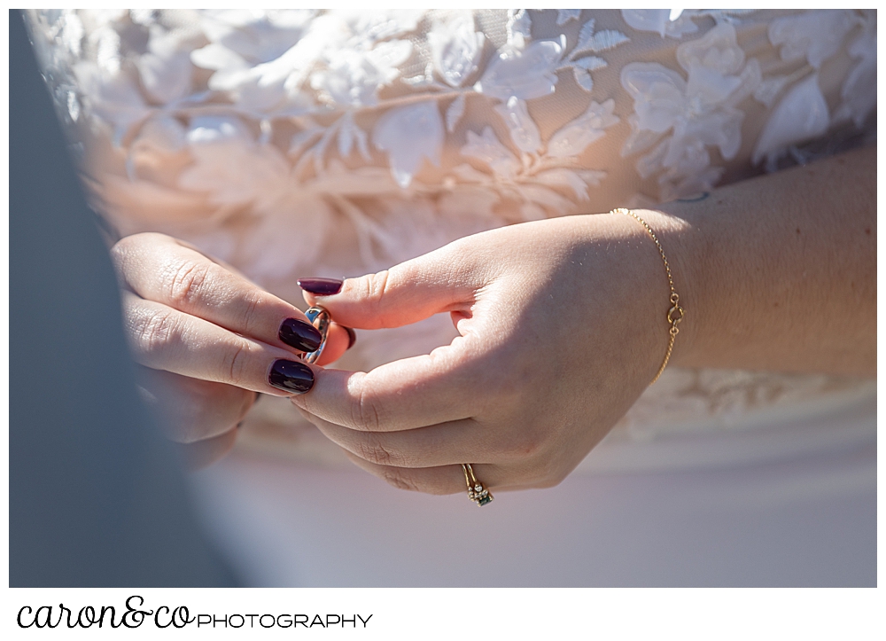 a bride holds the grooms wedding band just before putting it on his finger