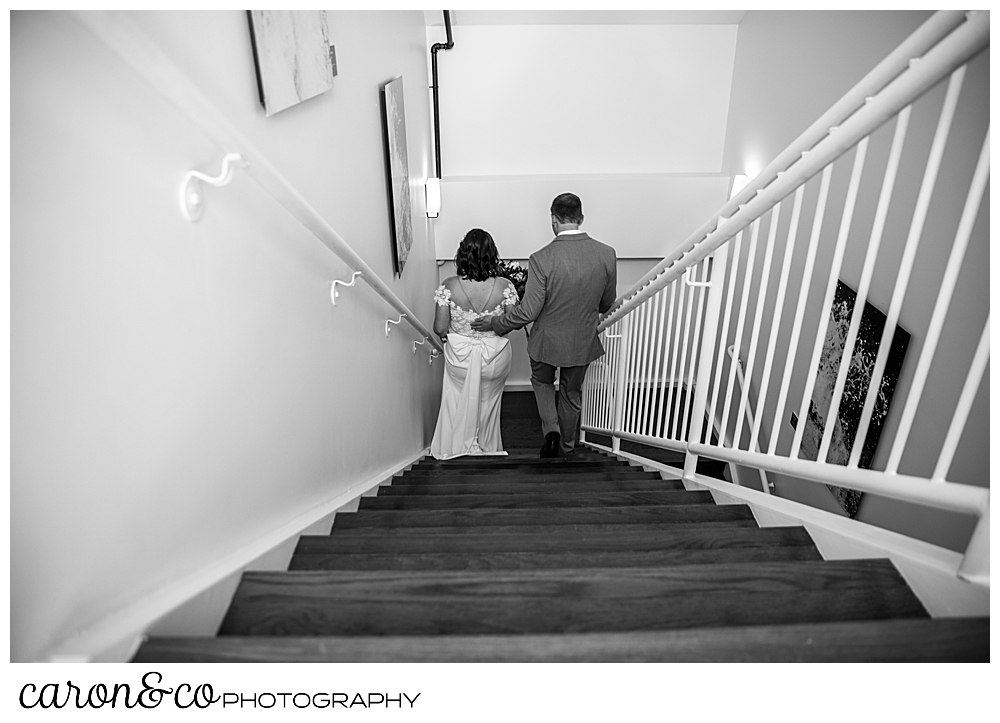 black and white photo of a bride and groom going down the stairs after their Portland Press Hotel wedding