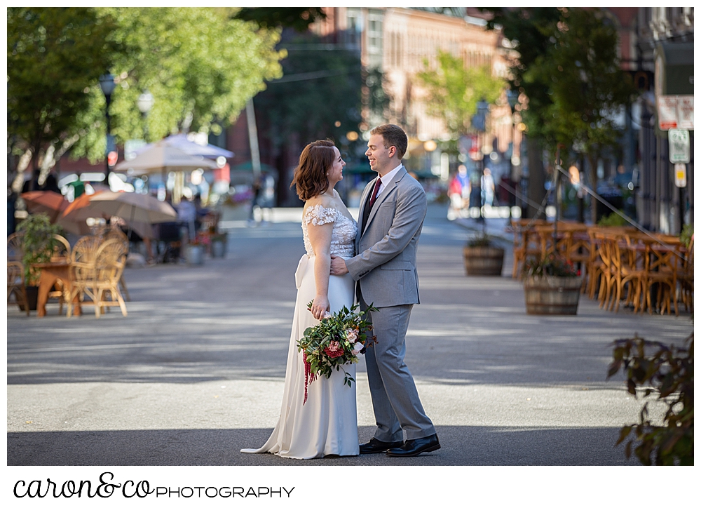 a bride and groom standing in the middle of the road in Portland Maine