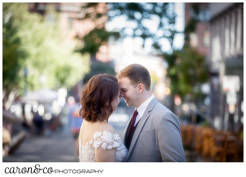 a bride and groom are touching their foreheads together and laughing