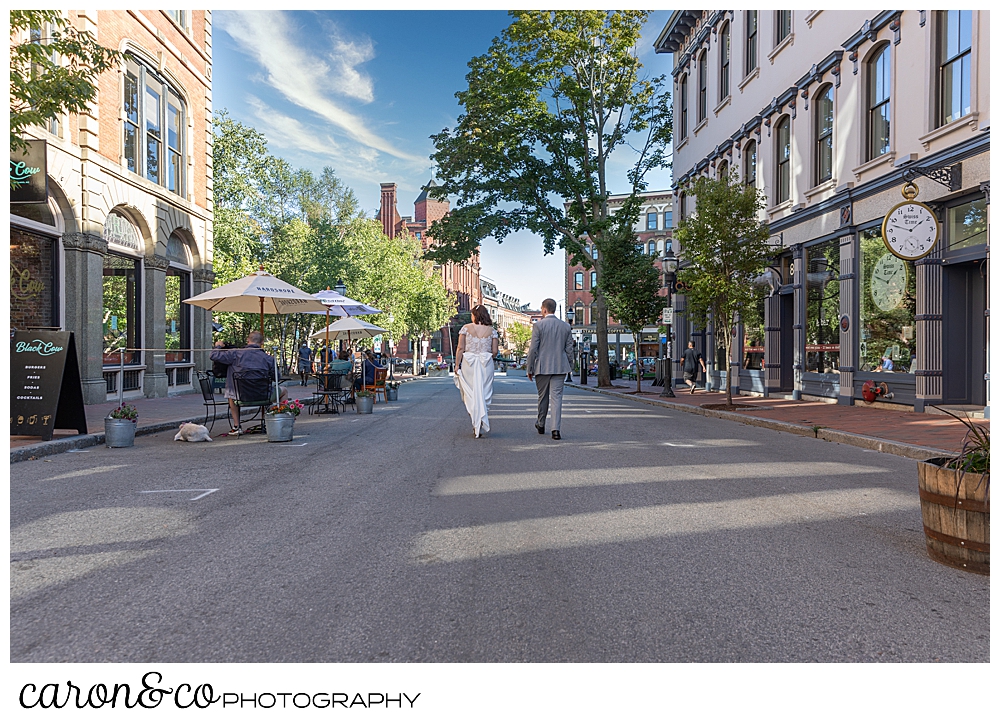 bride and groom walking down the middle of the road in Portland Maine