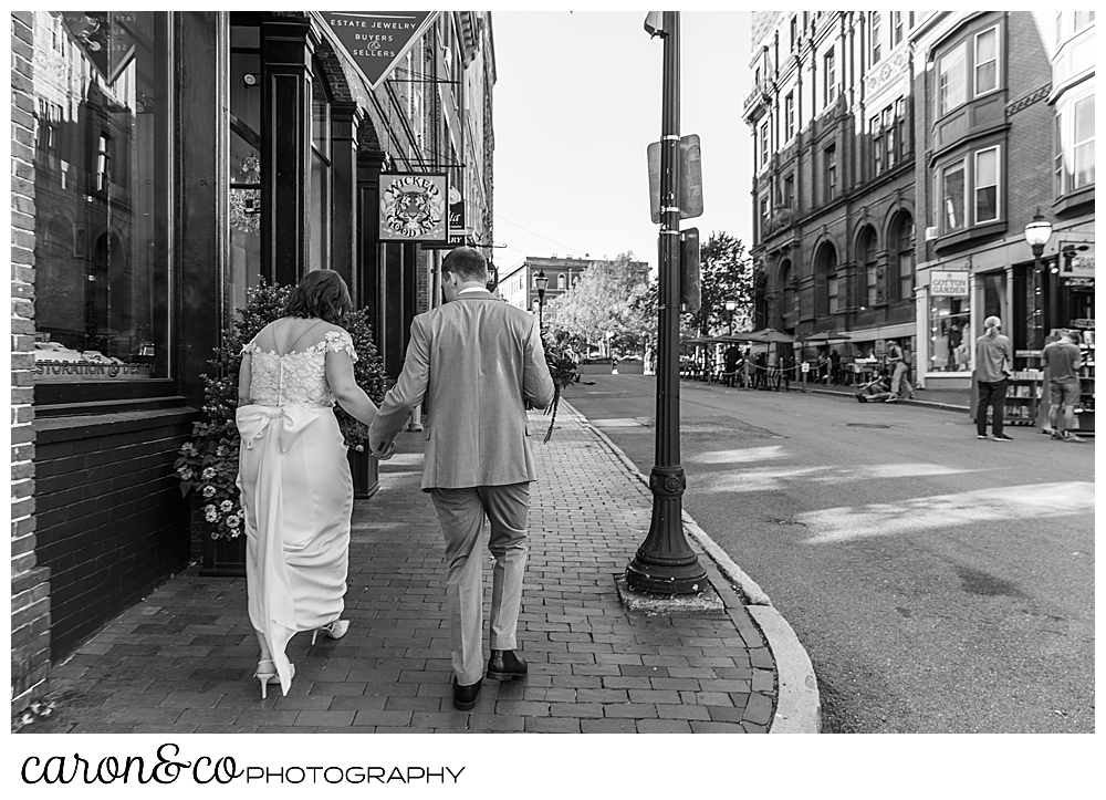 black and white photo of a black and white photo of a bride and groom walking down a sidewalk in Portland Maine