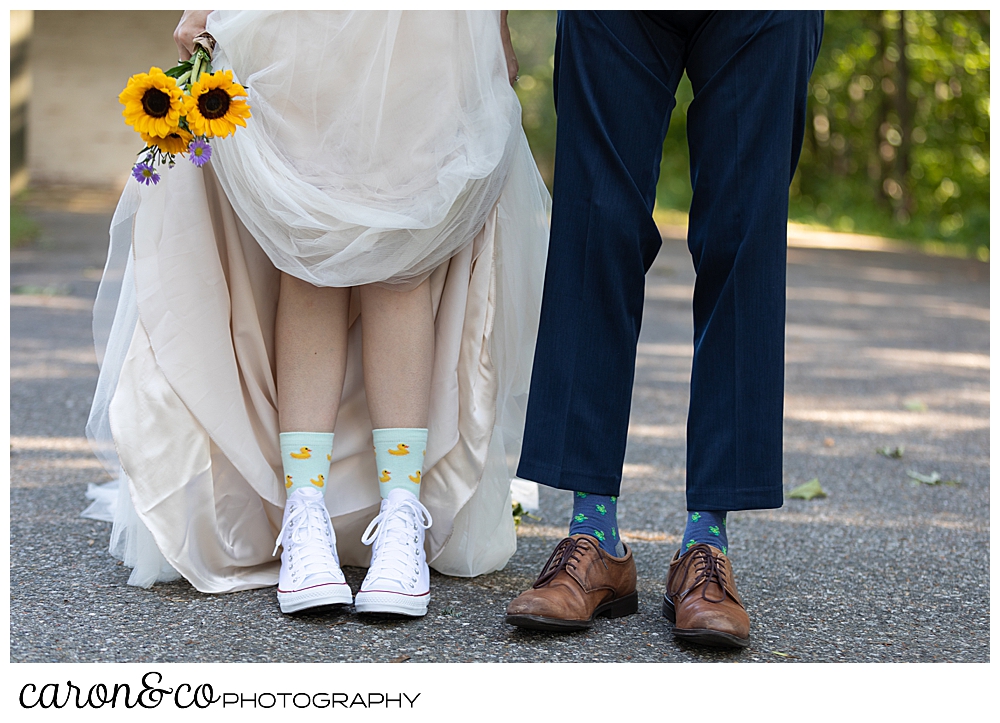 bride and groom standing side by side, bride is holding her dress, you can see their fun socks and shoes