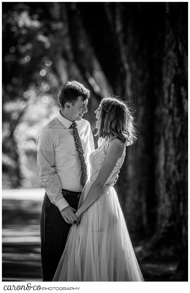 black and white photo of a bride and groom standing close together, looking at one another