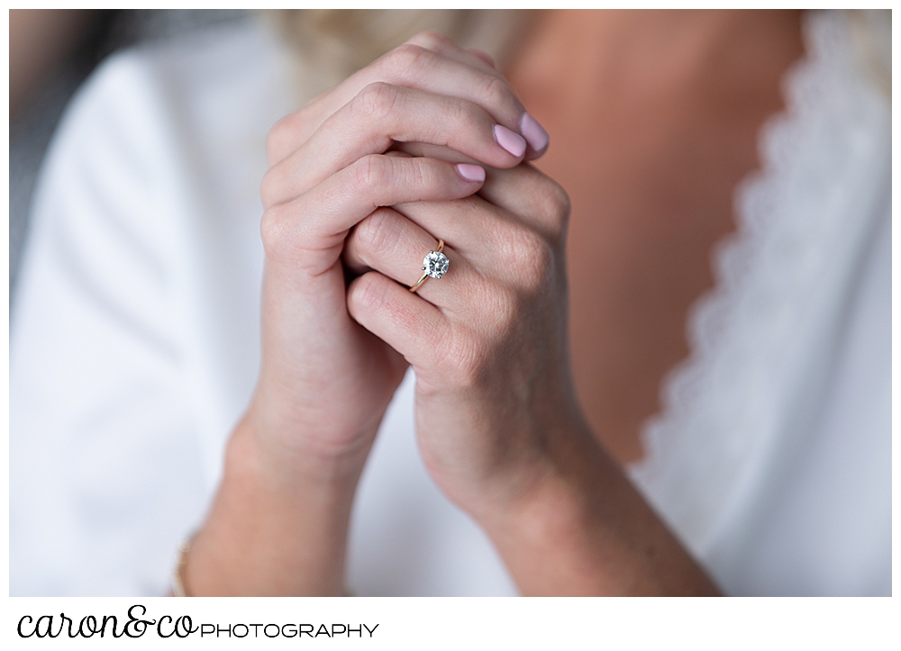 a woman's hands are clasped, you can see her diamond engagement ring