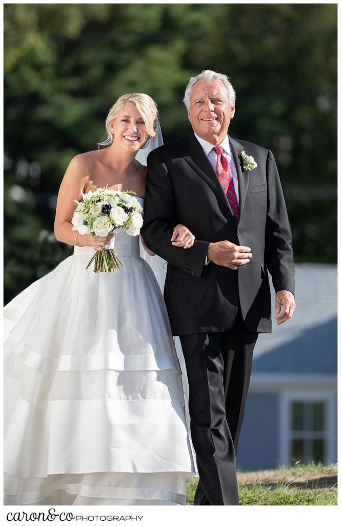 A smiling bride and her father during the processional at a timeless Boothbay Harbor wedding in Maine