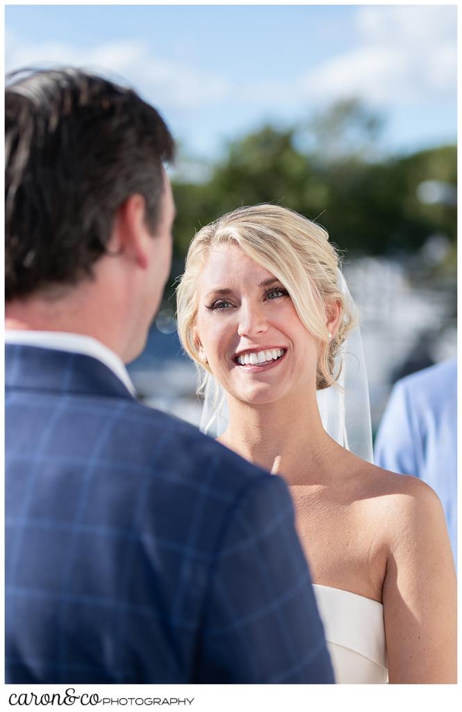 A bride smiles at her groom during a Boothbay Harbor Maine wedding ceremony