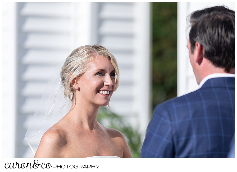 A bride smiles at her groom during their timeless Boothbay Harbor wedding, in Maine