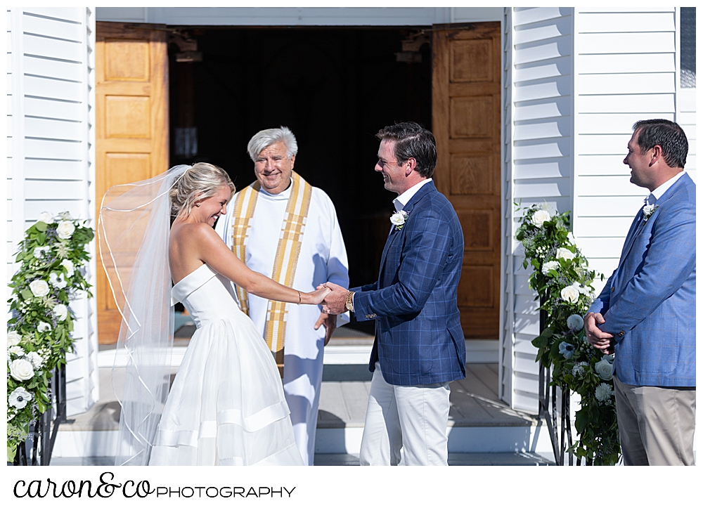 bride and groom smile at each other at their Our Lady Queen of Peace Catholic Church wedding ceremony