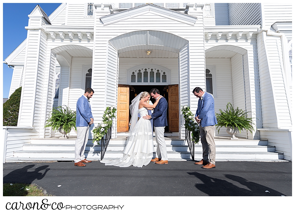 A Catholic priest blesses the bride and groom at an Our Lady Queen of Peace, Boothbay Harbor, Maine wedding