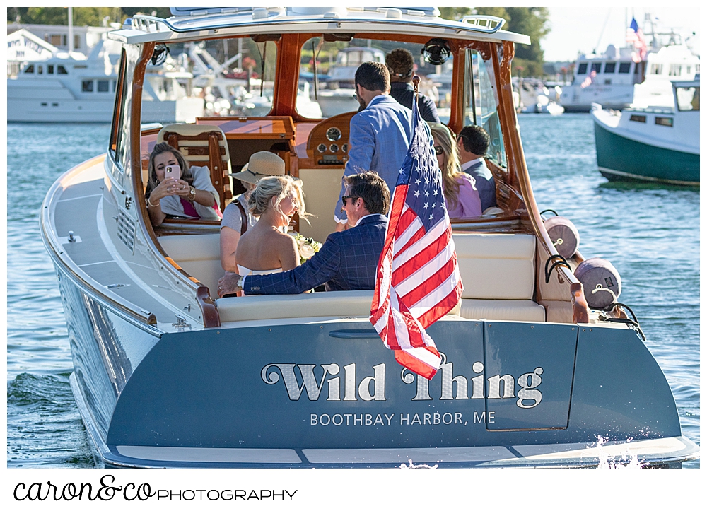 A bride and groom and their bridal party aboard the Hinckley Yachts Picnic Boat Wild Thing, during their timeless Boothbay Harbor wedding, Boothbay harbor, Maine