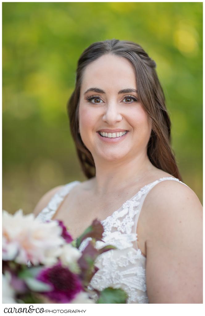 bridal portrait of a dark-haired bride, holding a bouquet of blush and dark red dahlias