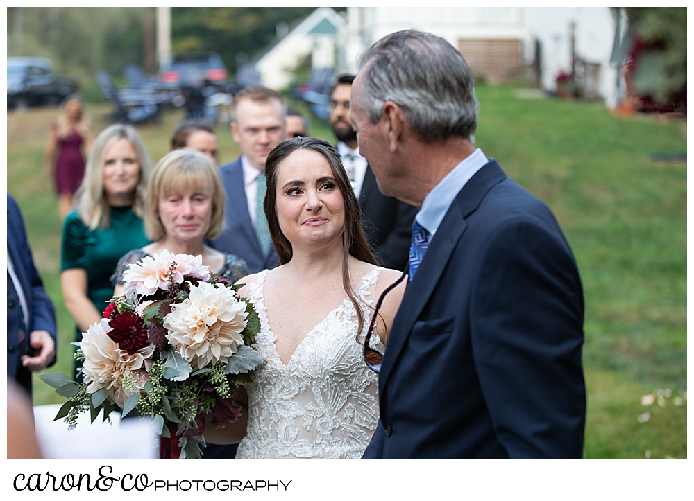 a bride looks at her father, as they reach the ceremony site for a Kennebunkport Maine wedding