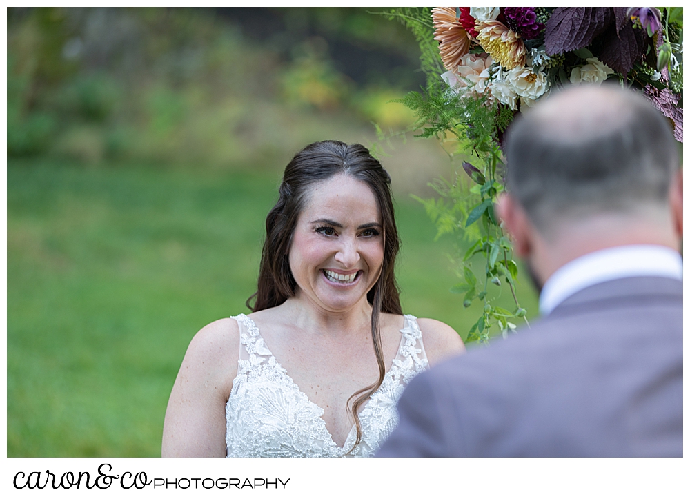 a bride smiles at her groom during their charming Kennebunkport Maine wedding ceremony