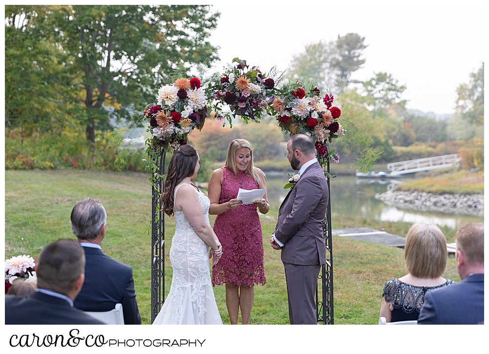 a bride and groom stand before their officiant at a charming Kennebunkport Maine wedding ceremony