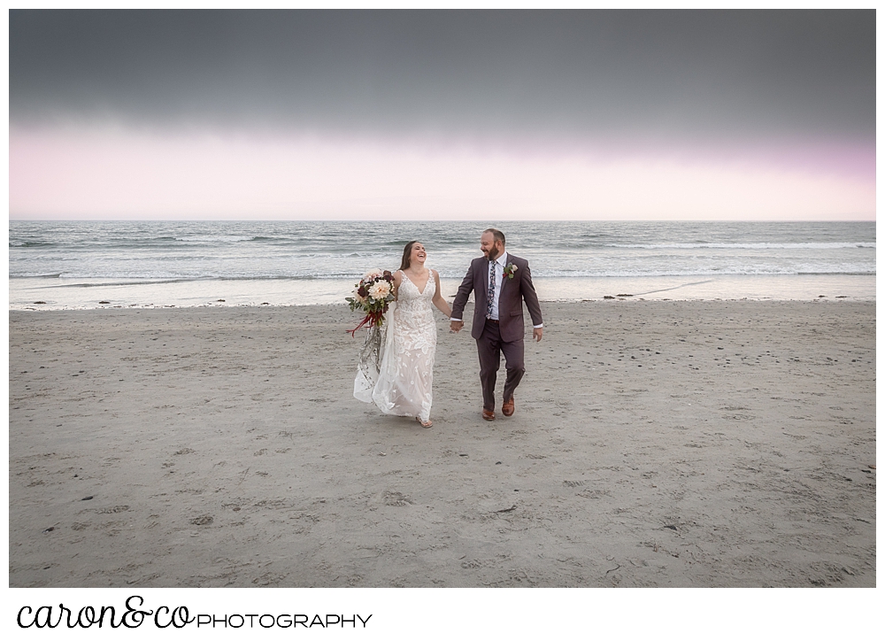 a bride and groom walking on a Kennebunk Maine beach